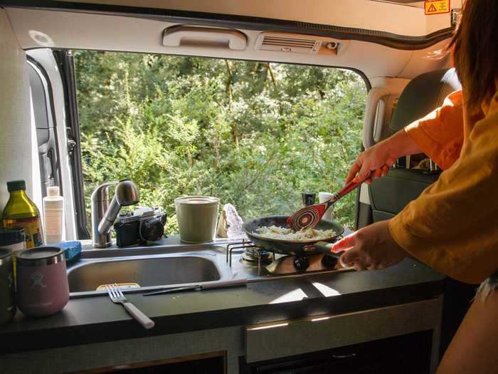 The sink and stove are placed in front of the van