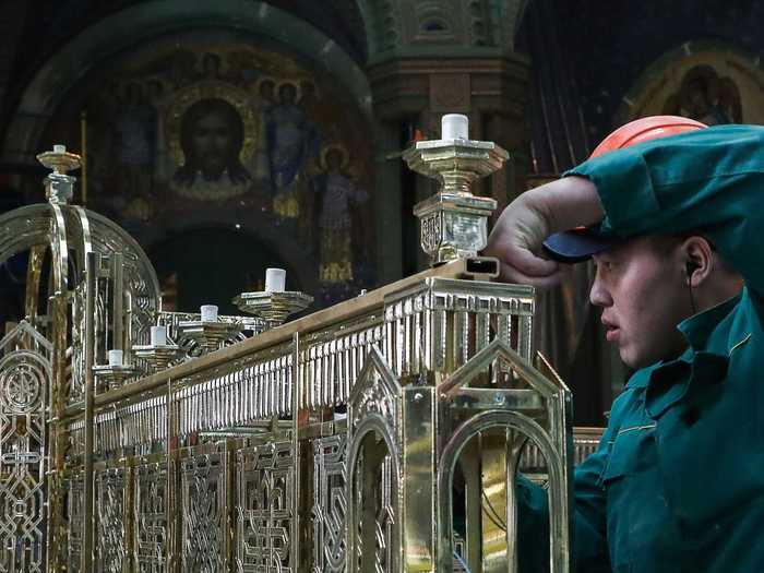 Here is a worker helping to install intricate ornamentation to be hung from the ceiling during the cathedral