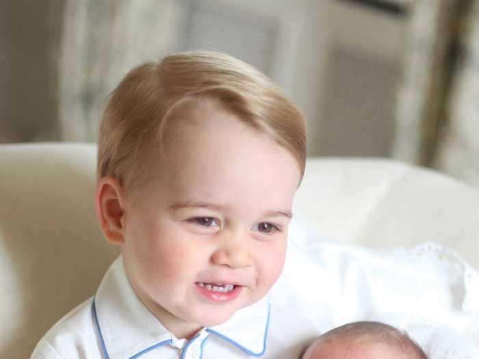 This image of Prince George cradling a newly-born Princess Charlotte "captures the pride and joy" he felt after the arrival of his sister in 2015.