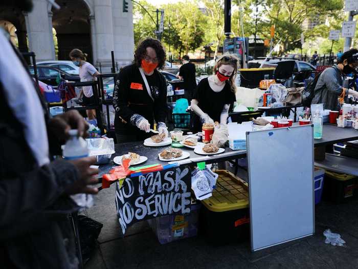 Though social distancing can be difficult throughout the park, many volunteers have made efforts to keep protesters protected from the coronavirus. Here, volunteers distributing food are seen wearing masks with a sign that says "no mask, no service."