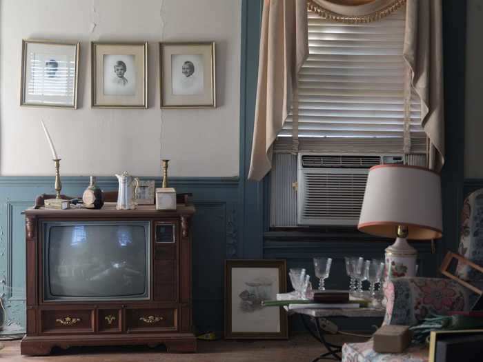 In another room, there is an old TV and an air-conditioning unit.