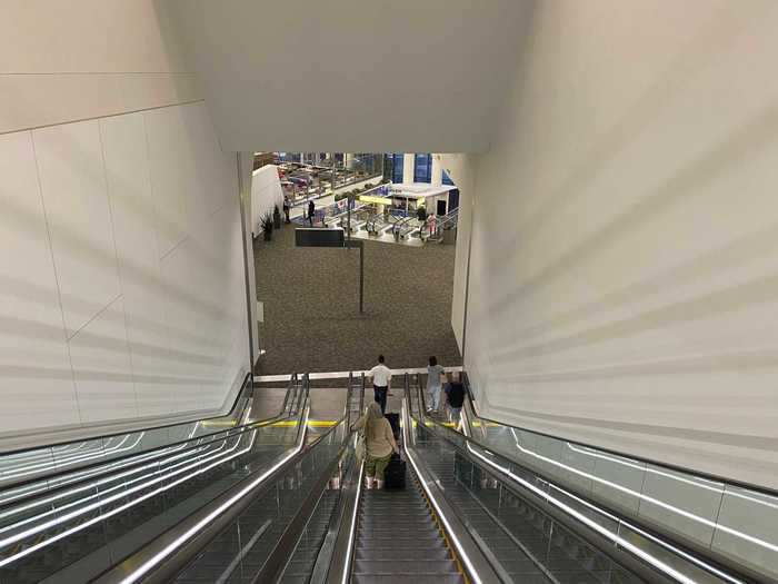 The four-escalator bank brings passengers first to the upper level of the concourse where United and Air Canada have lounges and there are some seating areas.