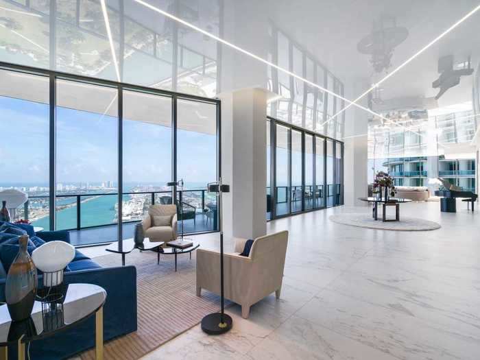 From the foyer, double doors open up to an 86-foot living room lined with floor-to-ceiling windows.