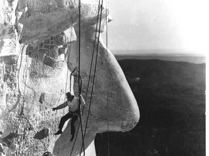 Close-up, the 20-foot noses look giant next to a worker dangling during construction in 1936.