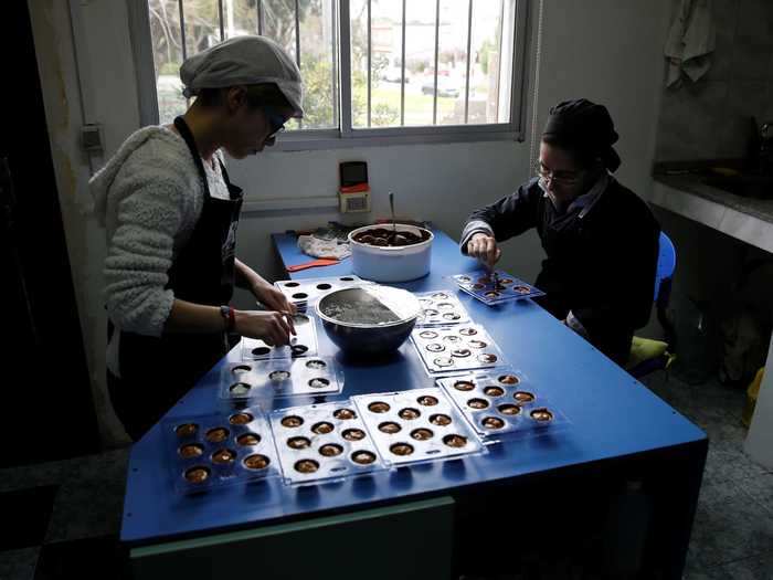 In this factory in Uruguay, workers form chocolate truffles using round molds.