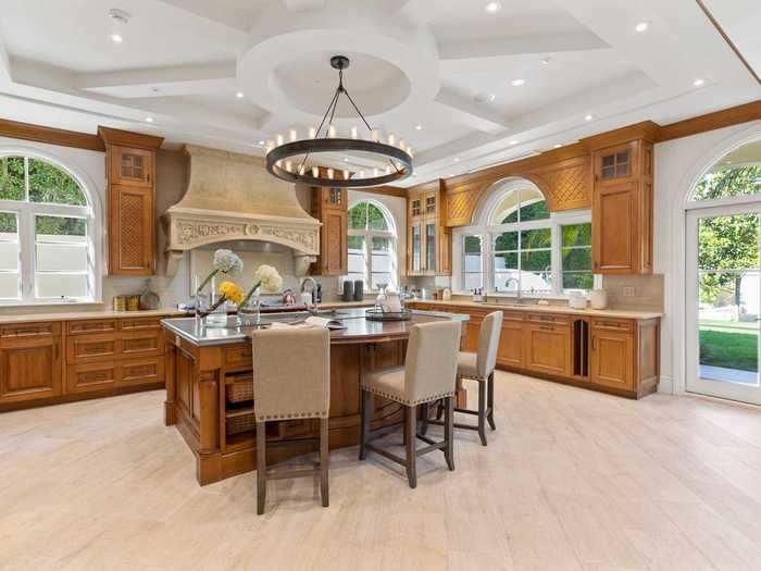 The kitchen comes with a large island, a marble chimney, and a handcrafted upscale La Cornue stove. The house is bathed in natural light thanks to its floor-to-ceiling windows and window-paned doors.