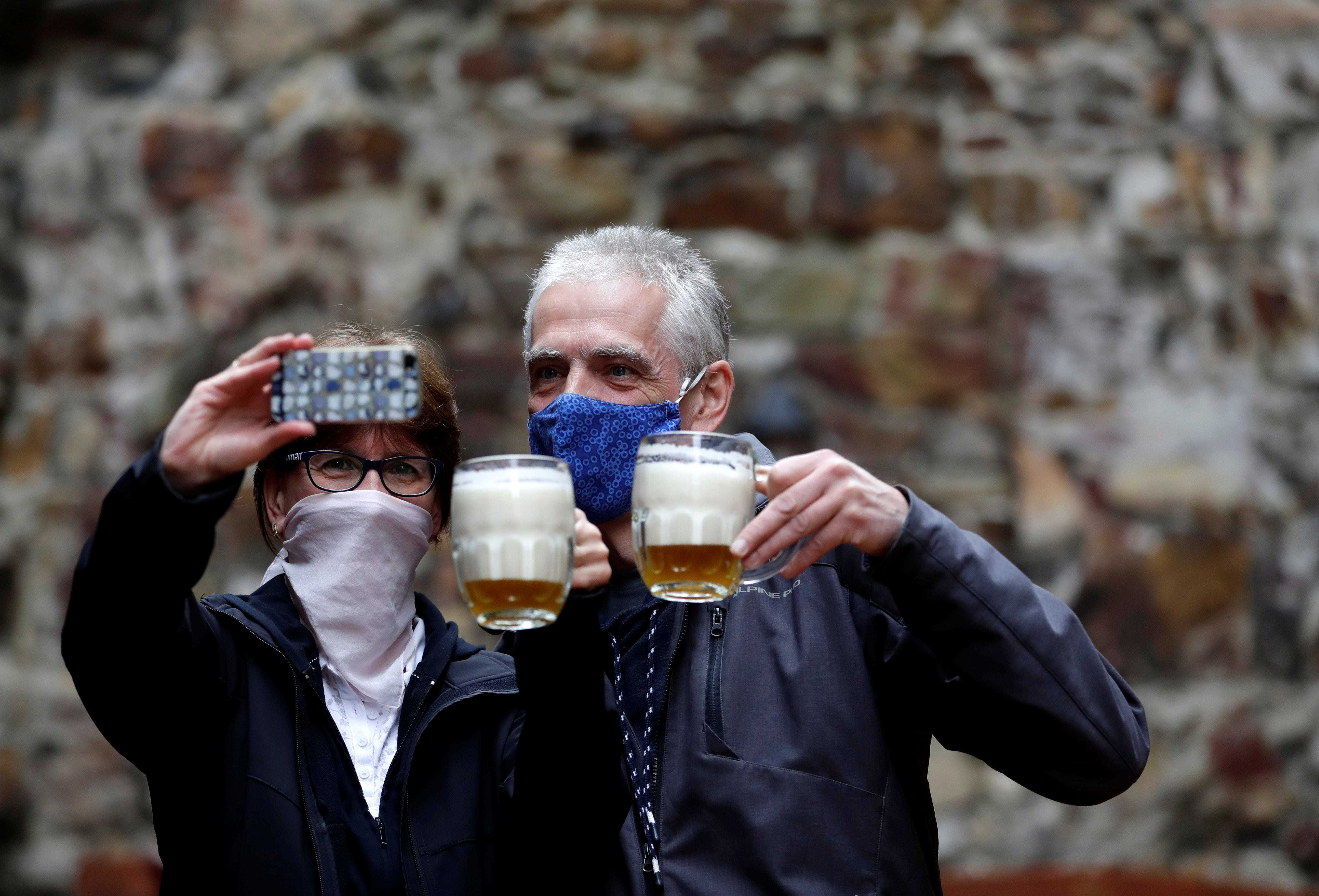 People take a selfie picture with their beers at an outdoor seating section of a pub, as the Czech government lifted more restrictions allowing restaurants with outdoor areas to re-open amid the coronavirus disease (COVID-19) outbreak, in Prague, Czech Republic, May 11, 2020. REUTERS/David W Cerny