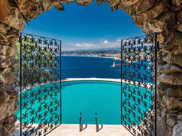 At the southern edge of the property, a circular outdoor saltwater swimming pool appears suspended over the water below.