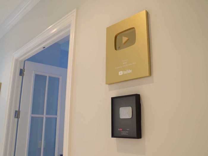 In the hallway, members display trophies from YouTube on subscriber milestones.