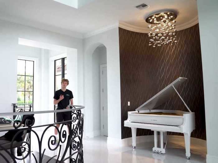 The living room has a chandelier and baby grand piano left behind by the previous owner.