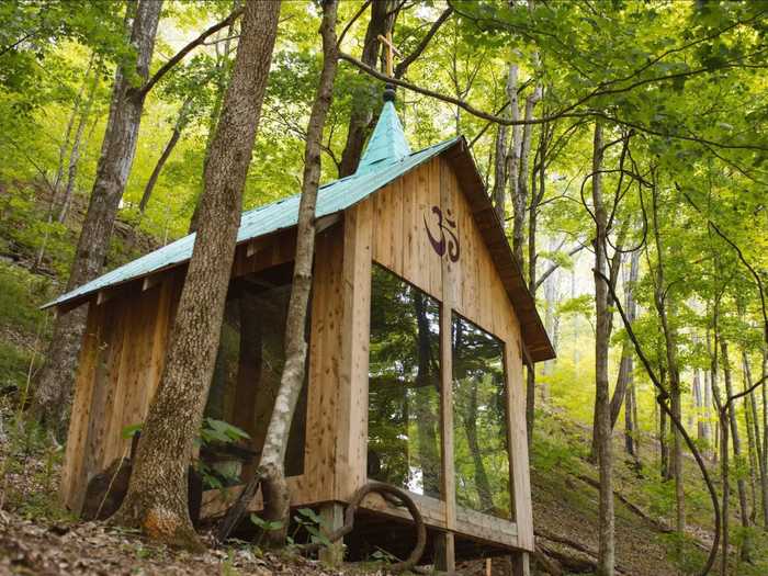 There is a peace sign carved on the inside of this tiny house in the woods of Tennessee for a reason. Glass windows on three sides, a wood-burning stove, and plenty of candles make for zen nature retreat.