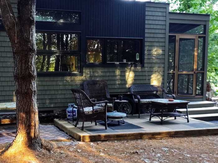 A screened-in porch and plastic lawn flamingoes add to the rural charm of this tiny house on a New Hampshire farm with a river running through it.