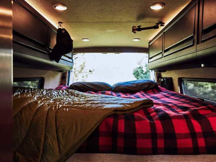 The bed — which is placed towards the rear of the van — is lined with overhead storage cabinets on both sides.