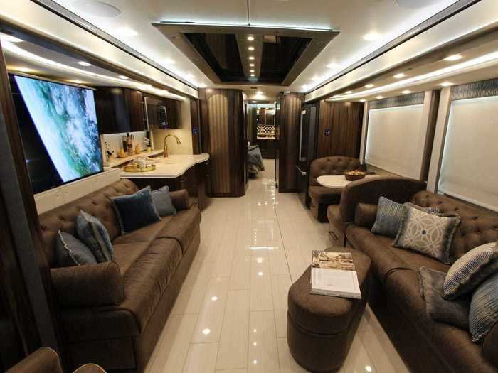 The RV has two couches and a full kitchen with a bedroom in the rear.