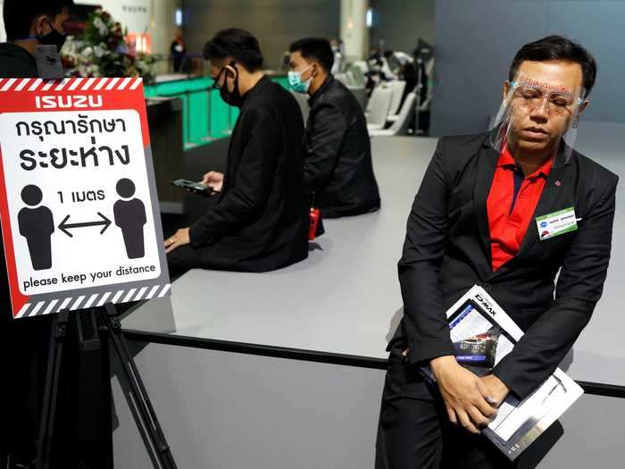 The show floor features plenty of reminders to maintain distance, including signs ...