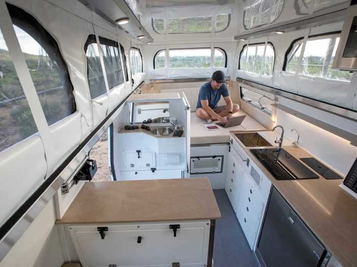 The dining space — which consists of a leather-topped seating area and a swivel table, — can be turned into a second bed to accompany the actual bed.