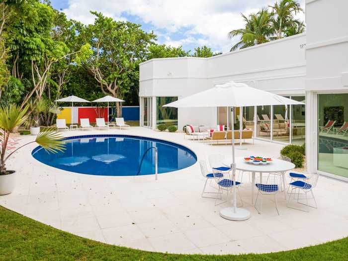 The home has a circular pool in the outdoor area, which also makes use of primary and vibrant colors.