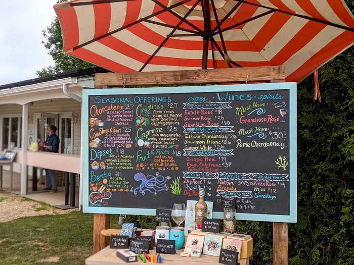 The first stop is a chalkboard menu that lists all the different wines, ciders, snacks, and tchotchkes, from glasses to magnets, that are for sale.