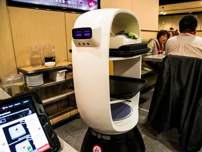 Chinese hotpot chain Haidilao employs non-humanoid robot servers that make facial expressions and speak to guests.