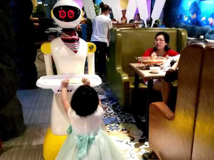 A robot waiter at a restaurant in Wuhan, China has expressive eyes on an LED screen.