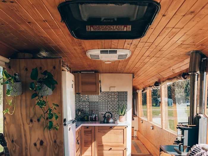 Inside, there is a cozy living space, with a quaint kitchen and a hallway that leads to the back of the bus.