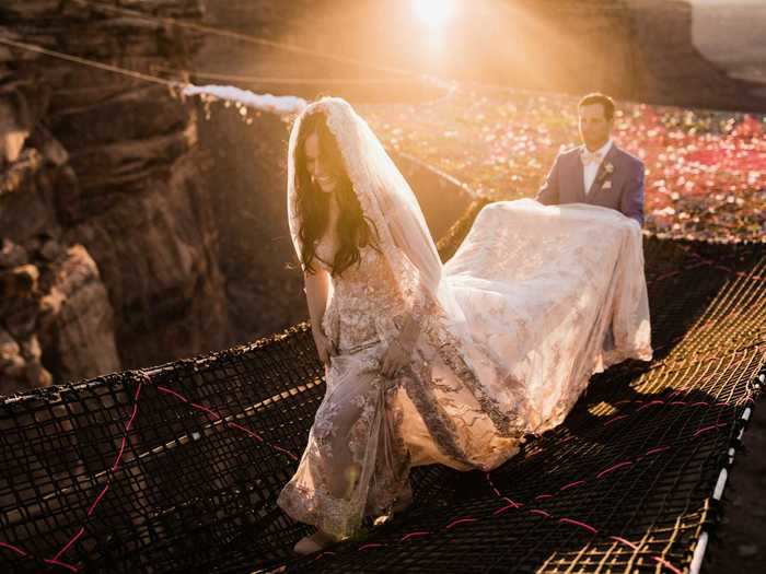 The bride wore a gown with a long train as she walked down the aisle, which was also suspended over the canyon.