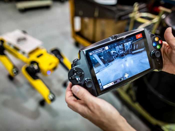 The handler navigates the robots through the plant with a handheld device that shows the camera view. It also has a stop feature in case of collision.