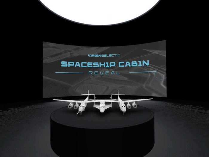 The tour began in a room showing a movie screen and digital model of SpaceShipTwo, VSS Unity (center), and its twin-hull mothership, VMS Eve, on a pedestal.