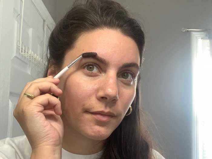 Steps 1 and 2: Brush your brows with a spoolie brush to ensure all of the hairs are going in their natural direction. Then, mix the tint and the developer in a small container, like a shot glass.