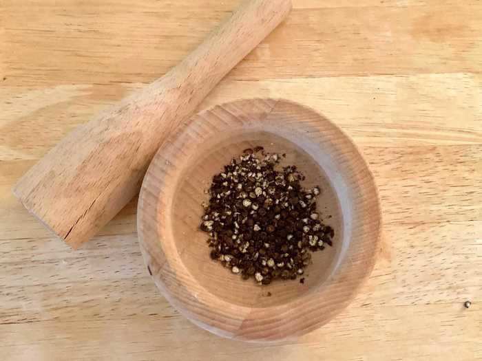 The recipe then calls for putting your black peppercorns in the pan and crushing them with a meat hammer or the end of a rolling pin.