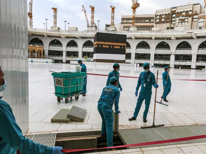 Photos shared by the Saudi Ministry of Media show workers sanitizing common spaces ...