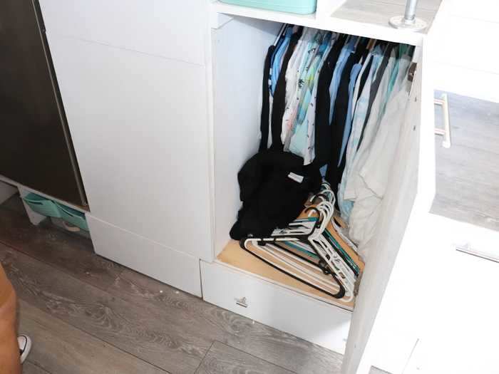 Another cabinet in her staircase acts as her closet, where she hangs her shirts.