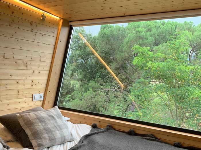 The bedroom wall has a large pane of glass, givings guests a panoramic view of the outdoors.