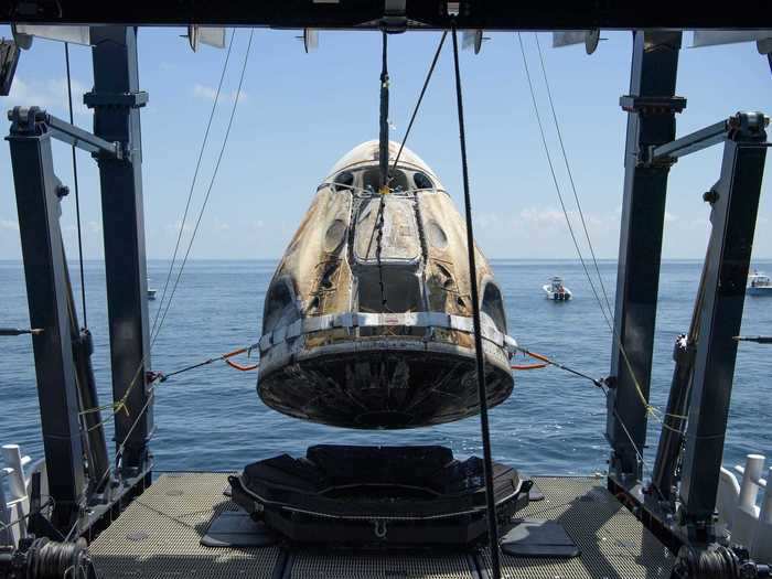 After clearing away the unauthorized boats, the recovery team lifted the toasted capsule out of the water.