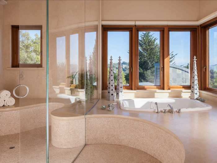 ... and a soaking tub with panoramic views of the surrounding landscape, as well as a walk-in, glass-walled shower.