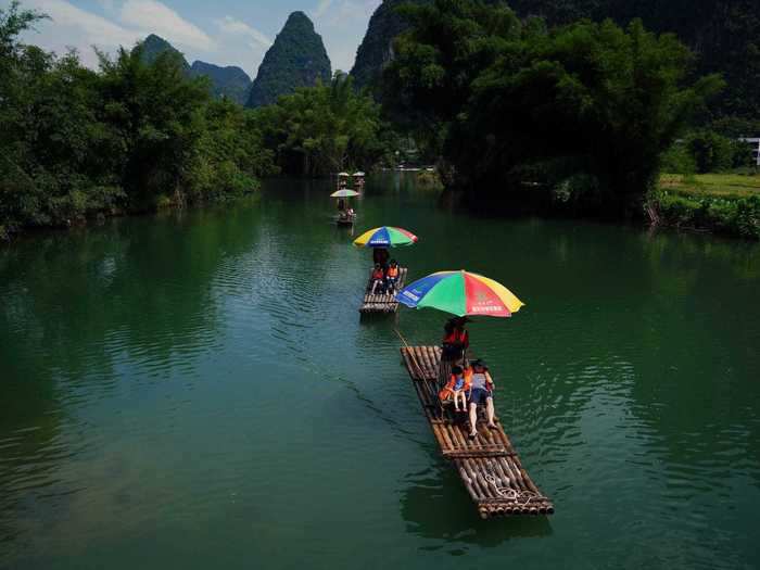 In China, tourists can ride on socially distant rafts along the Yulong river in Yangshuo.