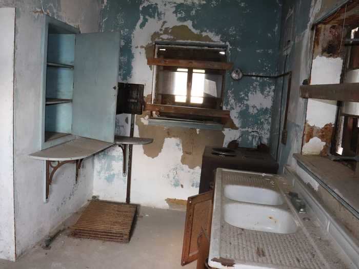 The kitchen came equipped with a cupboard, a stove, and two sinks.