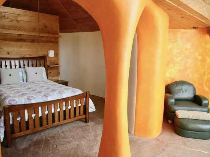 The bedroom has curved walls and windows that look out to the mountains.