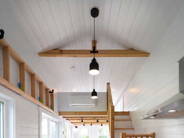 The ladder stored on the wall above the kitchen space is designed to access the one loft that doesn