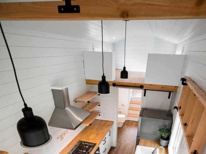 The client who requested the build had a hand in picking the color palette of the tiny home, resulting in its bright white walls with wood and black colored accents.