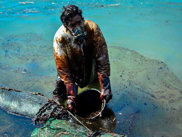 Despite local official orders, volunteers drenched in oil "have taken matters into their own hands" to try and contain the leak.