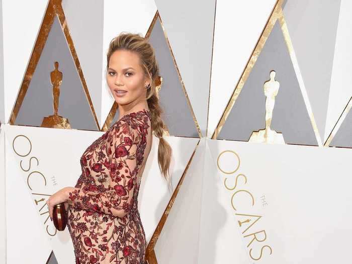 At the Oscars that month, Teigen stunned in a semi-sheer gown with a red floral print.