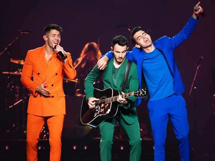 They wear bright, colorful outfits on their Happiness Begins tour.