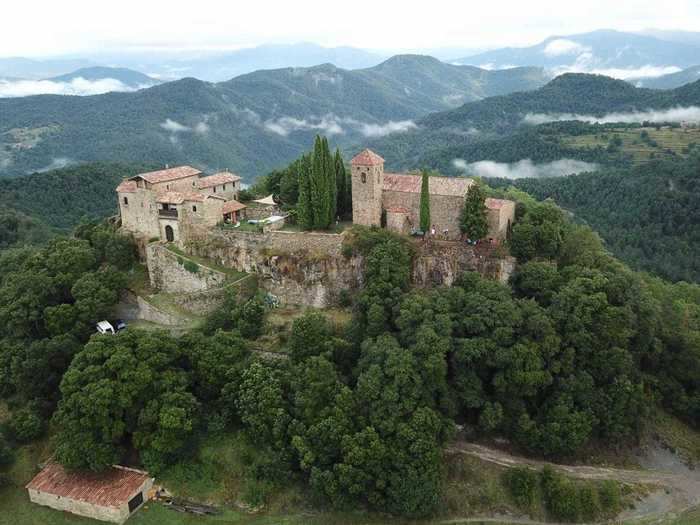 This Spanish castle sits on a tree-covered hill.