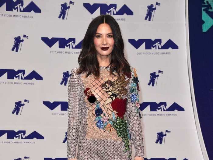 For her VMAs outfit, Olivia Munn wore a long-sleeved metallic shift dress with a sheer cut-out panel overlaid with fishnet and sequin details.