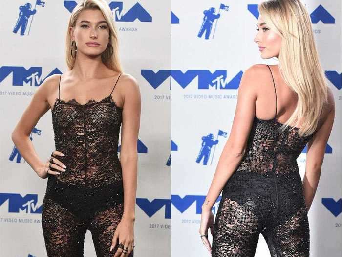 On the same night, Hailey Baldwin wore a second see-through jumpsuit — this time, in a black lace material with visible black underwear and a pair of knee-high velvet boots.