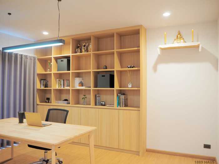 They turned the third floor into an office, complete with bright lighting and a spacious shelving unit.