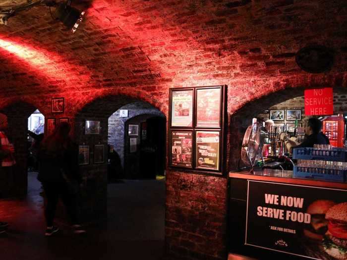 The main room of the club is full of character, with brick walls, low arches, and dim red lighting.