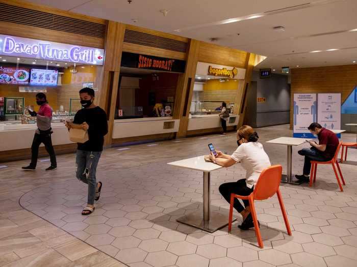 At this food court in Manila, only one person is allowed at each table.