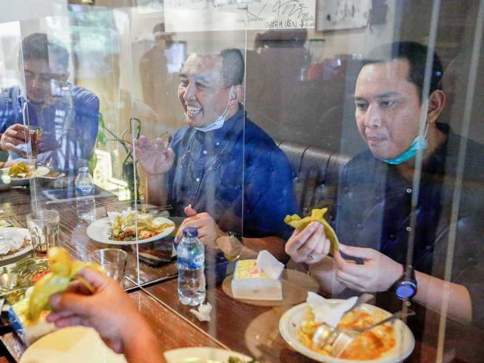 In Jakarta, Indonesia, restaurants can open for dine-in at 50% capacity, The Jakarta Post reported on June 9. At Atjeh Connection, a cafe, clear partitions separate patrons.